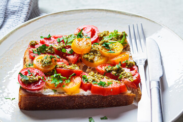 Toast with tomatoes, pesto and curd cheese. Italian cuisine concept.