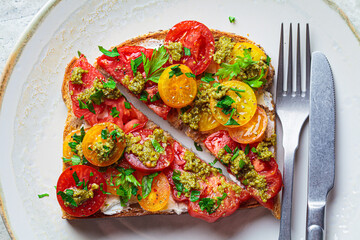 Toast with tomatoes, pesto and curd cheese. Italian cuisine concept.