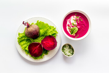 Cream soup made of red beet with raw beet roots