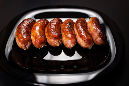 Roasted kupati on black plate. Fried sausages close up on black.