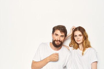 Fototapeta premium Cheerful man and woman in white t-shirts embrace friendship together