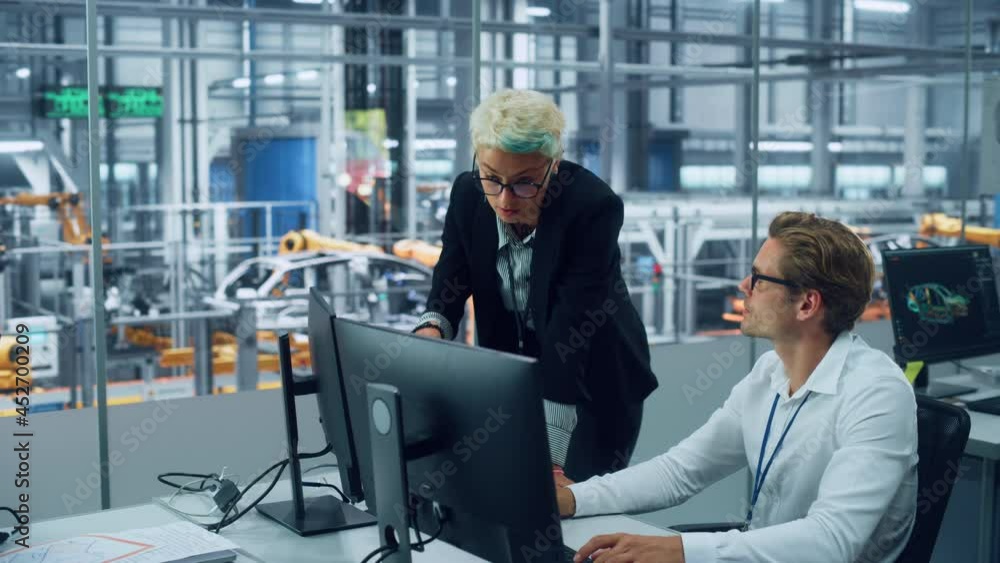 Poster two automotive engineers discussing concept car blueprints on desktop computer in modern office at a