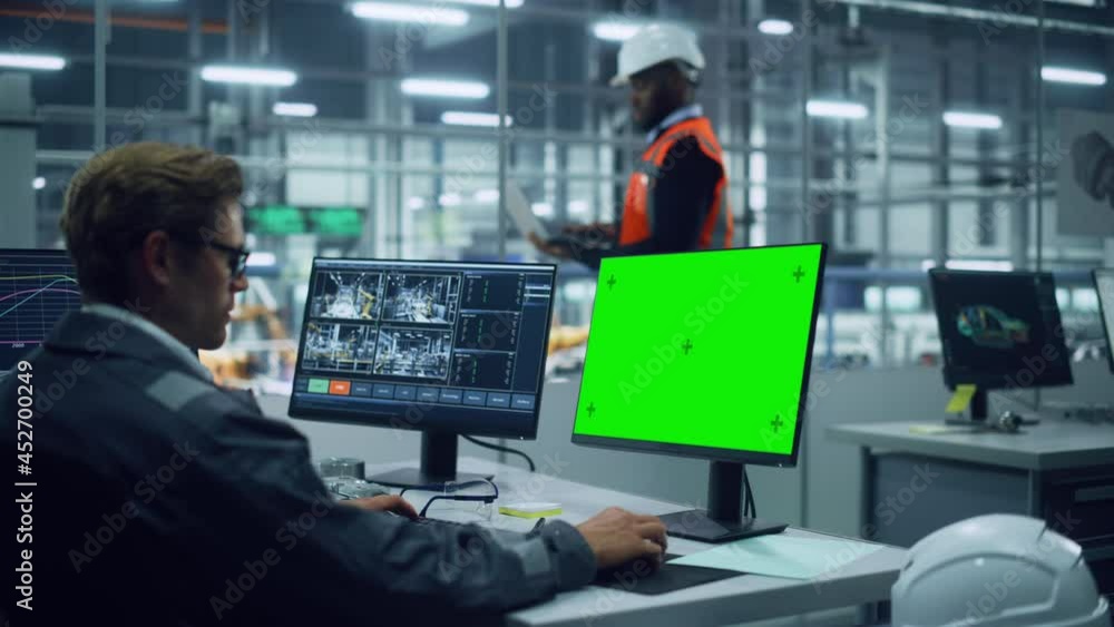 Leinwandbilder African American Engineer Using Laptop Computer and Looking Out of the Office at a Car Assembly Plant. Vehicle Factory Line Operator Working at Desk with Computer with Green Screen Display.