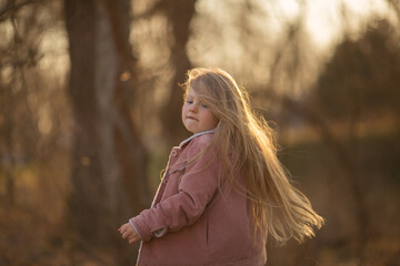 a little girl walks in the park in the spring