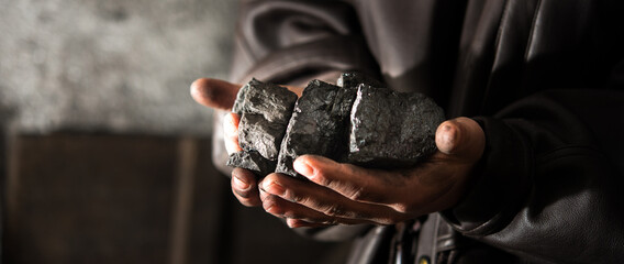 Coal mining : coal miner in the man hands of coal background. Picture idea about coal mining or...