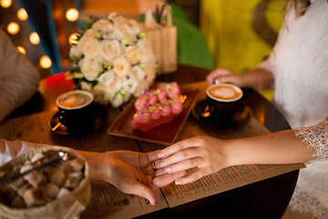 wedding two hands with wedding rings and a bouquet of the bride hold each other