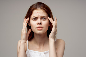 beautiful woman in a white t-shirt pimples on the face isolated background