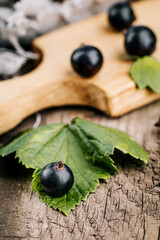 Fresh black currant. A handful of berries on a wooden table