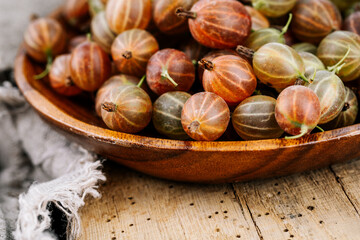 Red gooseberries on a wooden table.
