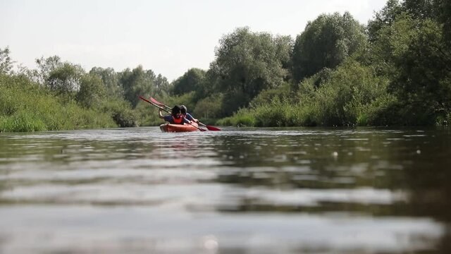 Kayaking on the River. Girls tourists kayaking down the river, teamwork