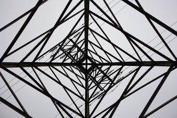 Directly Below Of Electricity Pylon Against Sky. Abstract pattern from bottom view of high voltage...