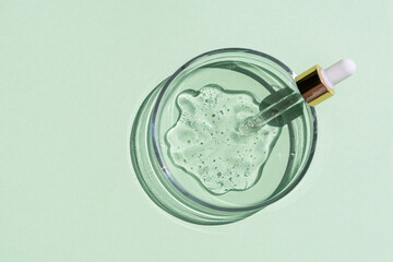 Flat lay of cosmetics serum and and laboratory glassware on bright green background. Organic cosmetics. Top view flat lay, copy space. Cosmetics, SPA branding, mock-up.