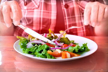 Someone adult eating greek salad in cafe