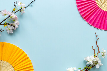 Chinese hand fans with cherry blossom branch. Top view