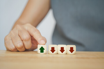 senior business woman choose green arrow up among down arrows on wood cubes for business growth concept