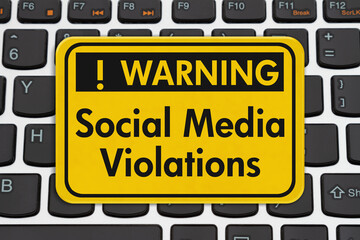 Social Media Violations message on yellow warning sign on a keyboard