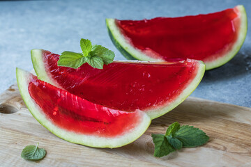 Homemade watermelon and mint dessert. Jelly in a watermelon  on a light background.