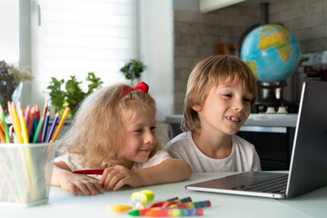 brother and sister study at home at laptop, children and gadgets