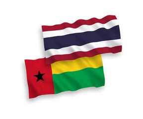 National vector fabric wave flags of Republic of Guinea Bissau and Thailand isolated on white background. 1 to 2 proportion.