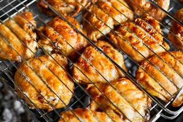 Grilled chicken thigh on the flaming grill. Close-up, selective focus
