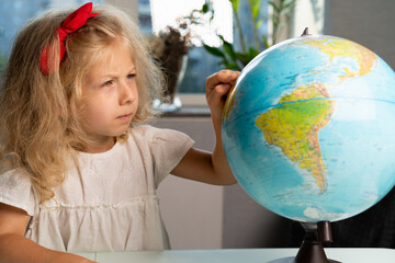 little girl with a globe, study geography, back to school