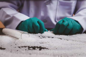 Man hands wearing gloves hold polymer pallet. Plastic beads on green gloved hand. polymer beads....