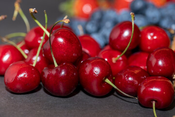 blueberries, cherries and strawberries on a dark background