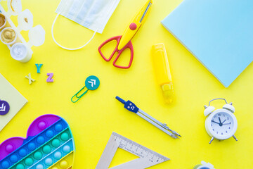 Close up of stationery and silicone toy popit. Flat lay composition. Yellow background. Space for...