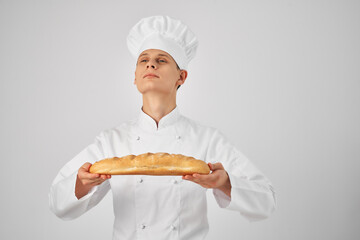 a man in a chef's uniform holding a loaf baker preparing food