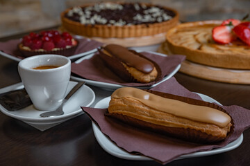 Eclairs with a cup of coffee in a cafe