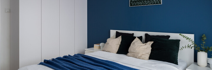Comfortable bedroom with blue wall, panorama