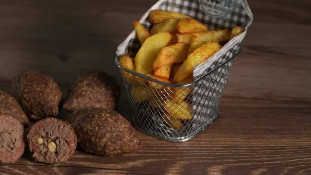 Traditional kebbe and French fries on brown table in lebanese restaurant, High quality 4k footage