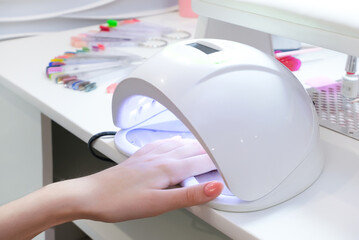 UV lamp gel polish manicure process. Salon procedure.