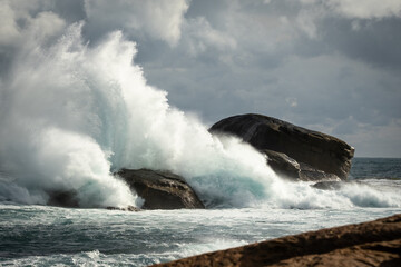 Rough weather big splash of waves on rocks at Redgate Beach, Western Australia