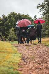 people walking down a way with umbrellas 