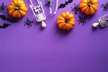 Happy Halloween party composition with pumpkins, skeletons, spiders, bats on violet background. Top...