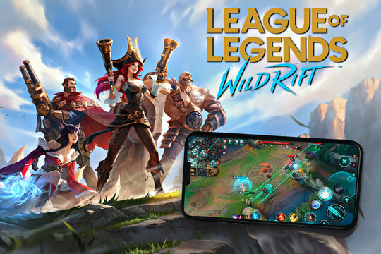League of Legends Wild Rift game app on the smartphone screen in the background with game image. Top view. Rio de Janeiro, RJ, Brazil. May 2021.