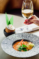 Thai cuisine. Tom yam soup with shrimps in a beautiful plate. Serving soup in a restaurant. High quality photo