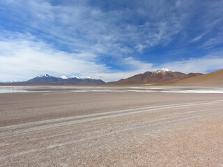 Fototapeta na wymiar A road near a salt lake in the stone desert of Bolivia near the city of Uyuni. Eduardo Avaroa Andean Fauna National Reserve