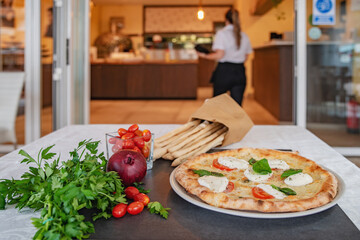 Freshly baked italian pizza margarita and restaurant on the background