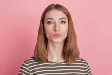 Fototapeta premium Portrait of romantic affectionate lady send air kiss look camera on pink background