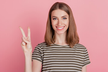 Portrait of charming positive friendly lady show v-sign toothy smile on pink background