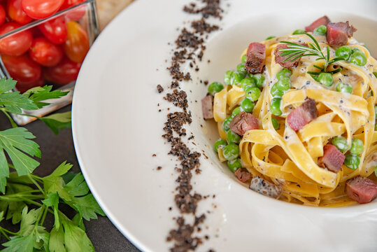 Italian Fettuccine Carbonara With Green Peas In A White Plate