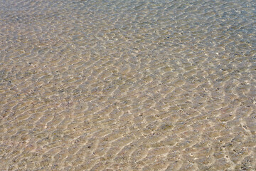 Surface of clear water on tropical sandy beach in Crete Greece.