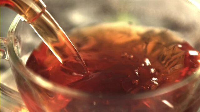Super slow motion black tea is poured into the cup. Macro background.Filmed on a high-speed camera at 1000 fps.