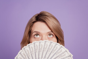 Photo of young pretty woman closing face bunch of dollars look up wealthy isolated over violet...