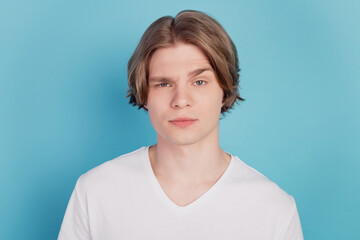 Photo of young man hesitate isolated over blue background