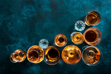 Strong alcohol drinks, hard liquors, spirits and distillates set in glasses: cognac, scotch,...