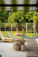 Beautiful backyard of the country house with sunbeds and flamingo figure