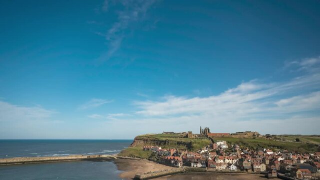 Timelapse view across Whitby Harbour to Whitby Abbey and St Mary's Church on the clifftop opposite. Slow moving clouds